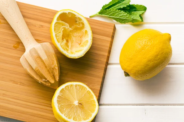 Squeezed lemon fruit and citrus reamer — Stock Photo, Image