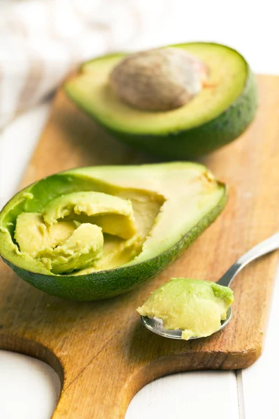 Green avocado on cutting board — Stock Photo, Image