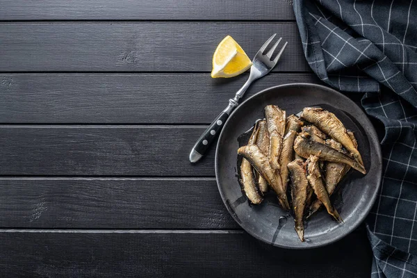 Smoked Sprats Plate Canned Sea Fish Black Table Top View — Stock Photo, Image