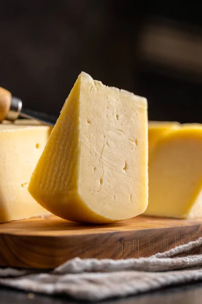 一块硬奶酪 刨花板上的切碎奶酪 — 图库照片