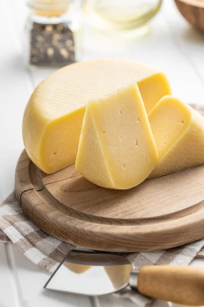 ハードチーズのブロック まな板の上でチーズをスライス — ストック写真