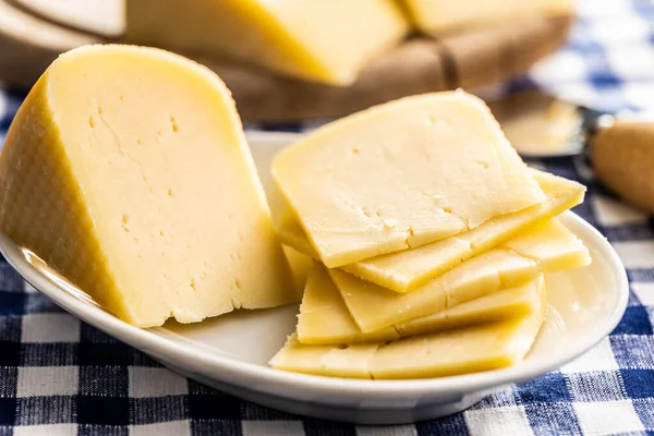 ハードチーズのブロック プレートの上にチーズをスライス — ストック写真