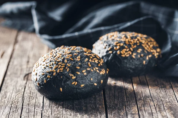Black Bun Dark Pastry Sesame Seeds Wooden Table — Stock Photo, Image