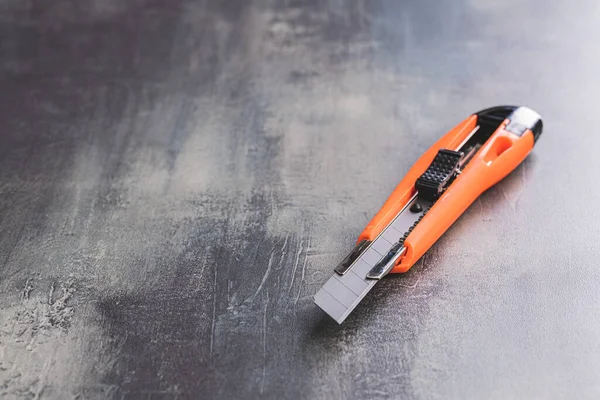 Orangefarbenes Werkzeugmesser Aus Plastik Auf Dem Tisch — Stockfoto