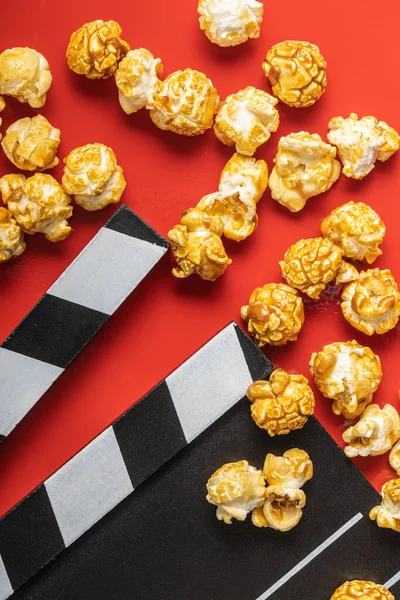 Słodki Karmelowy Popcorn Klaszcząca Deska Czerwonym Tle Widok Góry — Zdjęcie stockowe