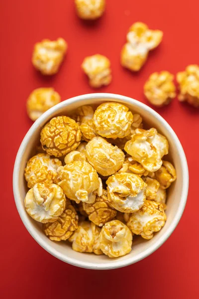 Sladký Karamelový Popcorn Šálku Červeném Pozadí Horní Pohled — Stock fotografie