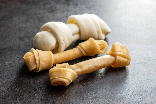 Delicacy for dogs. Chewing bone for dog on black table.