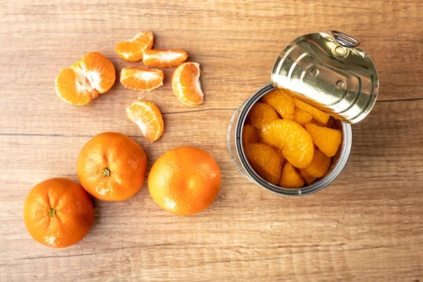 罐装橘子 在木桌上的罐头里 有腌制的芒果 顶部视图 — 图库照片