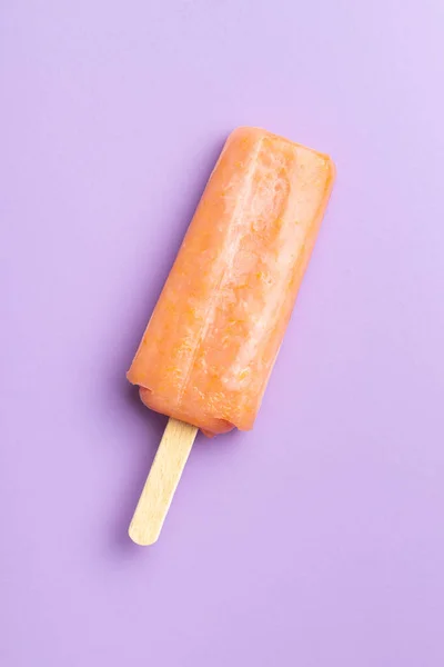 Fruity ice lolly. Sweet popsicle on a violet background. Top view.