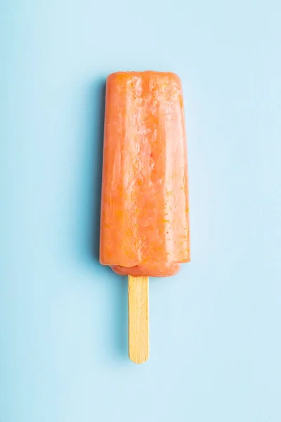 Fruity ice lolly. Sweet popsicle on a blue table. Top view.