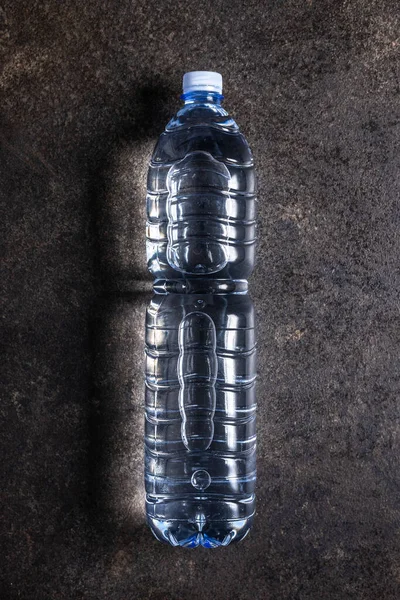 Plastic water bottle on a black table. Top view.