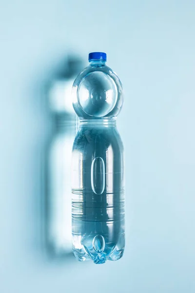 Plastic Water Bottle Blue Background Top View 免版税图库照片