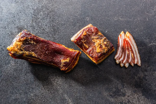 Whole Sliced Smoked Bacon Black Table Top View — Stock fotografie