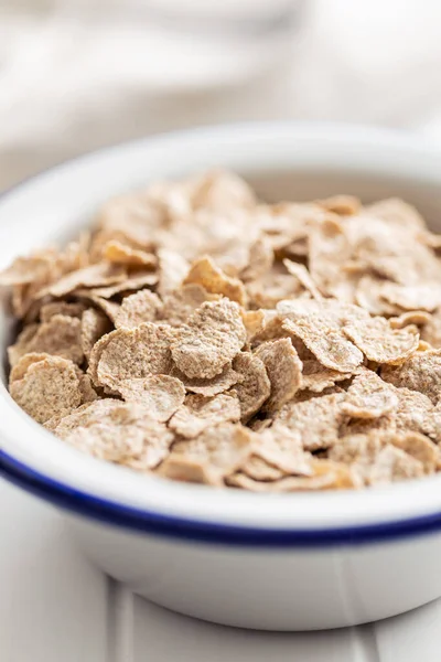 Whole grain cereal flakes. Wholegrain breakfast cereals in bowl on a kitchen table.