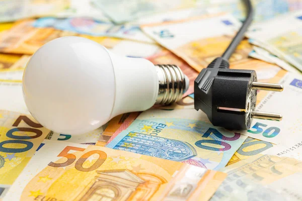 Electric plug, light bulb and the euro money. Concept of increasing electricity prices.