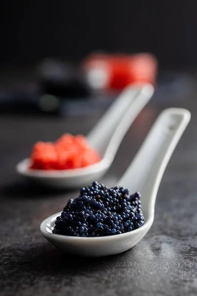 Roter Und Schwarzer Kaviar Keramiklöffel Auf Dem Dunklen Tisch — Stockfoto