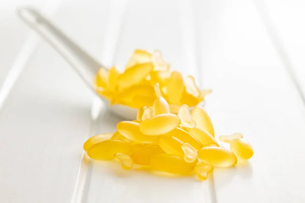Cápsulas Óleo Peixe Comprimidos Ómega Amarelos Colher Mesa Branca — Fotografia de Stock