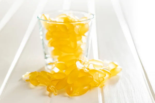 Tobolky Rybím Olejem Žlutá Omega Pilulky Skle Bílém Stole — Stock fotografie