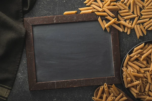 Black Chalkboard Ucooked Whole Grain Pasta Raw Penne Pasta Top — Stock Photo, Image