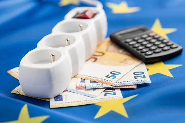 电源插座和欧元钱挂在欧洲货币联盟的旗帜上 能源危机的概念 — 图库照片