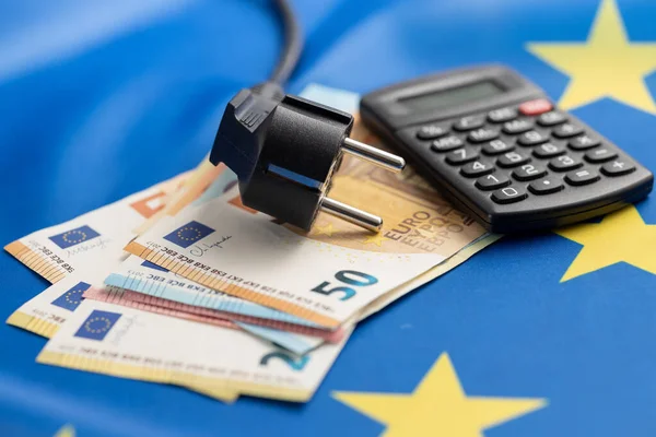 电源插头和欧元钱挂在欧洲货币联盟的旗帜上 能源危机的概念 — 图库照片