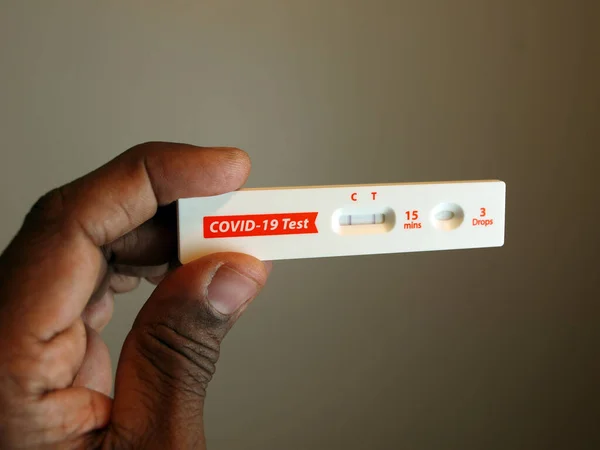 African American Hand Holding Covid Home Test Kit Showing Positive — Stock Photo, Image