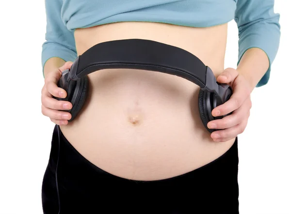 Headphones on a pregnant woman's abdomen — Stock Photo, Image