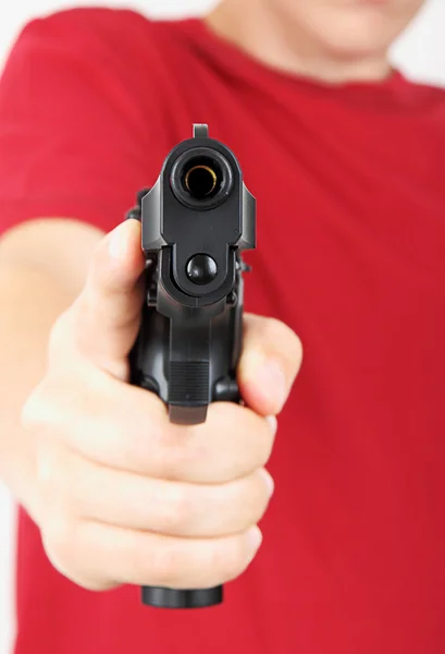 Teenager with a gun in his hand, focus on the gun — Stock Photo, Image