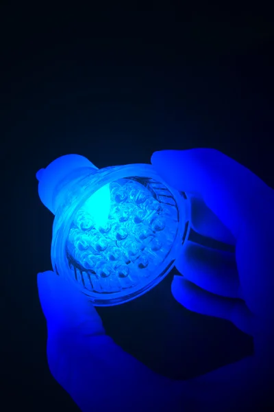 Lâmpada led azul na mão . — Fotografia de Stock