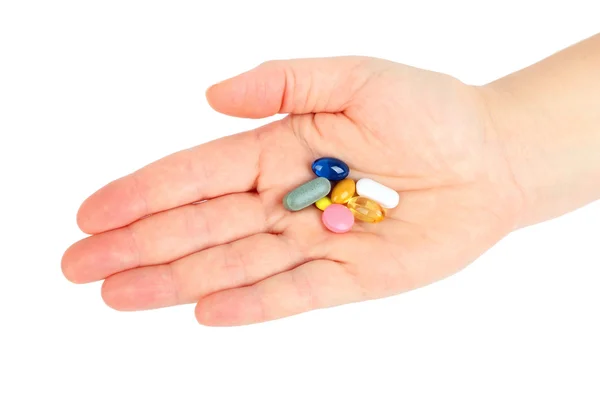 Mão com pílulas no fundo branco — Fotografia de Stock