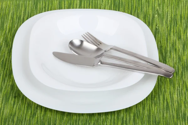 Un plato blanco con utensilios — Foto de Stock