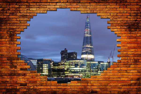 Night city through brick frame. Urban abstract concept. — Stock Photo, Image