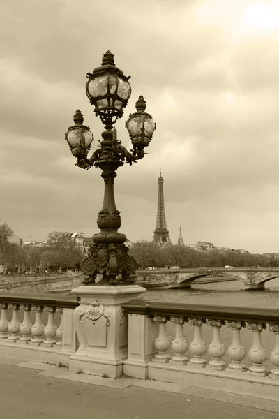 Street lantern on the Alexandre III Bridge with Eiffel Tower in Paris, France, sepia picture. — Stock Photo, Image