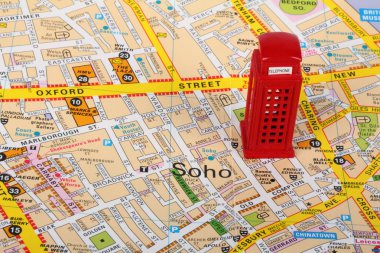 Small model of a red phone box  on top of a map of London clipart