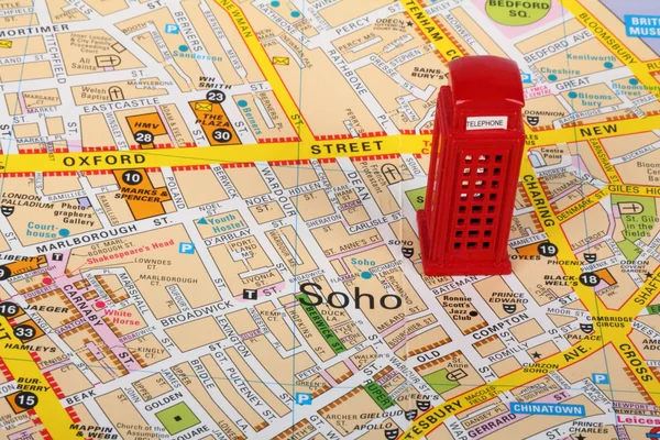 Pequeno modelo de uma caixa de telefone vermelha no topo de um mapa de Londres — Fotografia de Stock