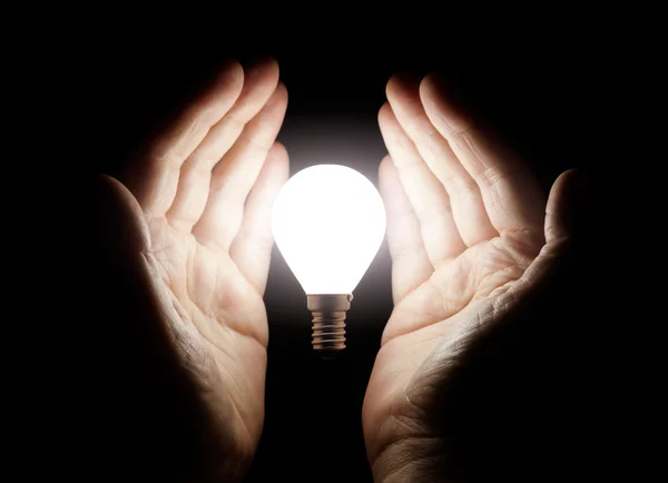 Hands holding light bulb Royalty Free Stock Images