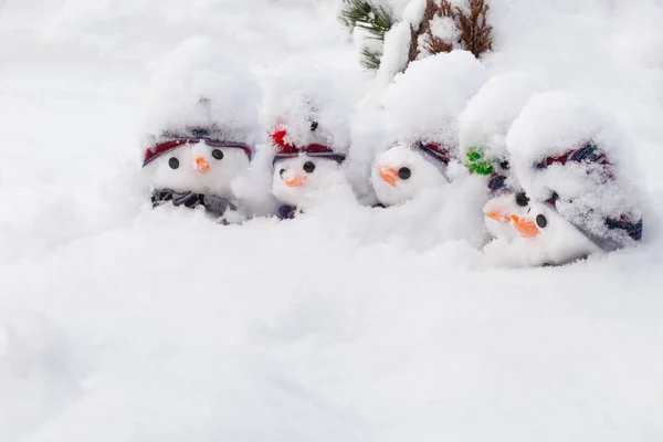 帽子とスカーフとニンジンの鼻を身に着けている新鮮な雪に覆われた5人のかわいい雪だるま 冬の雪の楽しさとホームラン — ストック写真