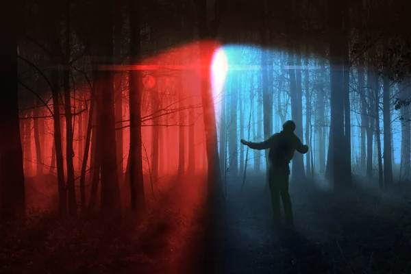 黑暗的林地森林里 一个男人在红色和蓝色的探照灯下奔跑 寒树景观中的犯罪概念 — 图库照片
