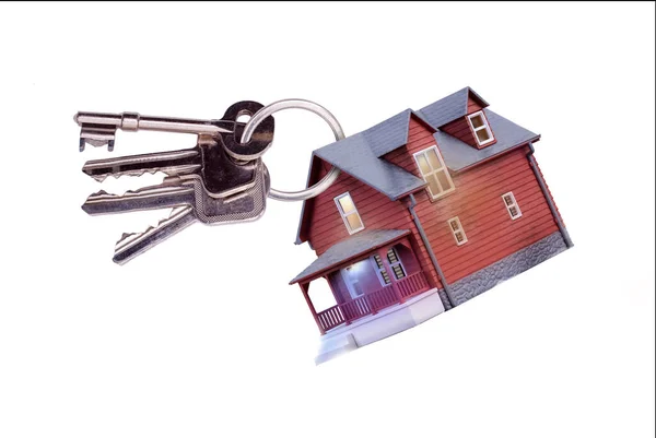 在钥匙圈上的玩具房子 钥匙是白色背景上隔离的家的钥匙 住房销售 住房所有权 地产代理 住房保险和建筑物安全的概念 — 图库照片