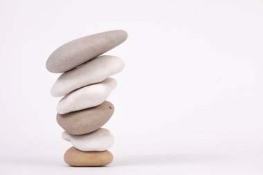 En küçüğü en altta, beyaz arkaplanda izole edilmiş çakıl taşı zen sütunlarını tersine çevir