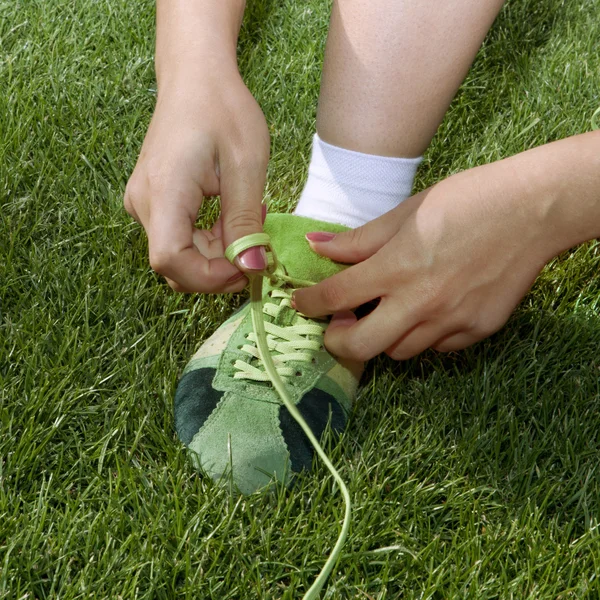 Girl ties laces on shoes — Stock Photo, Image