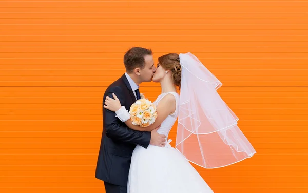 Bröllop brud och brudgum på ljusa orange bakgrund Stockbild