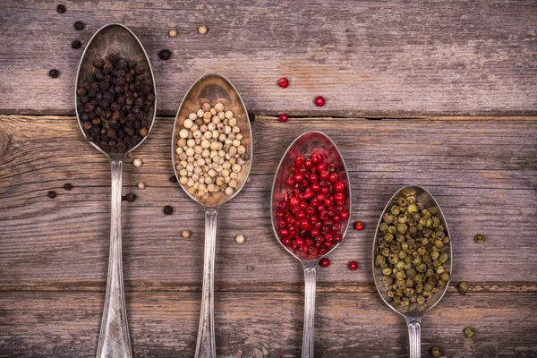 Peppercorns em colheres de prata — Fotografia de Stock