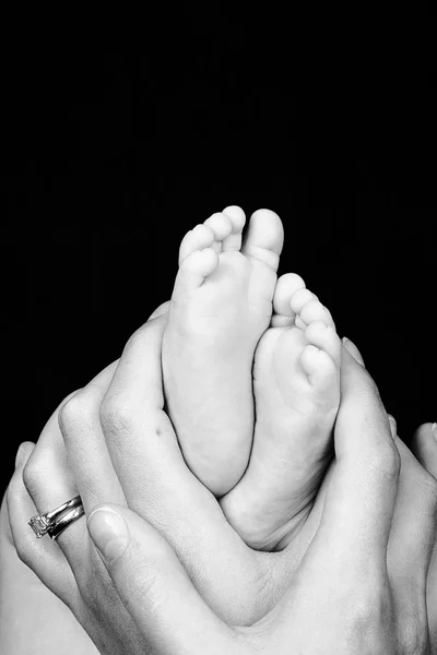 Mãe segura pés de filho — Fotografia de Stock