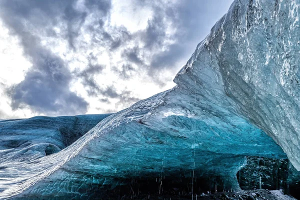 アイスランドの氷河洞窟のオーバーハング 洞窟は青の色合いで着色され 多くの場合 火山灰から形成された黒い層があります — ストック写真