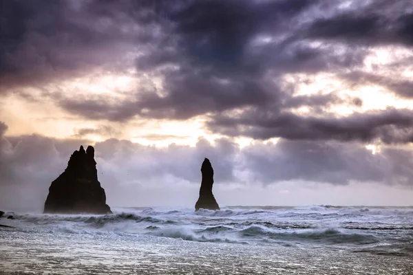 日出日落时 里尼斯兰加玄武岩柱屹立在冰岛海岸的汹涌大海中 由于冰岛人的神话 这里的地层也被称为巨怪 — 图库照片