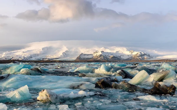 冰岛东南部与Vatnajkull国家公园接壤的Jokulsarlon冰川湖中的冰山 Vatnajkull冰川的一部分与周围积雪覆盖的高山相连 — 图库照片