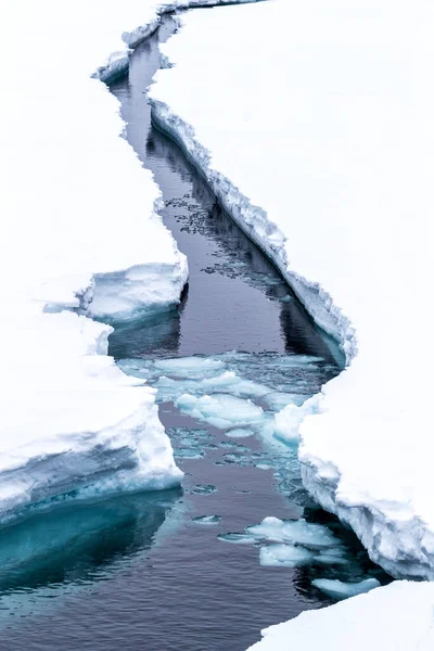 A crack in the ice. The ice shelf opens up as an icebreaker ship passes through. Svalbard, a Norwegian archipelago between mainland Norway and the North Pole and in the arctic circle.