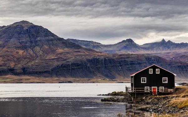 冰岛东峡湾朱皮沃古尔的船屋 峡湾和山脉 在暴风雨的天空下 静谧的水面上 一派风景如画的景象 秋天的颜色在山坡上被挑出来 — 图库照片