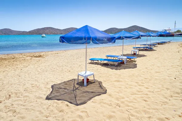 Blauwe parasols aan Egeïsche zee — Stockfoto